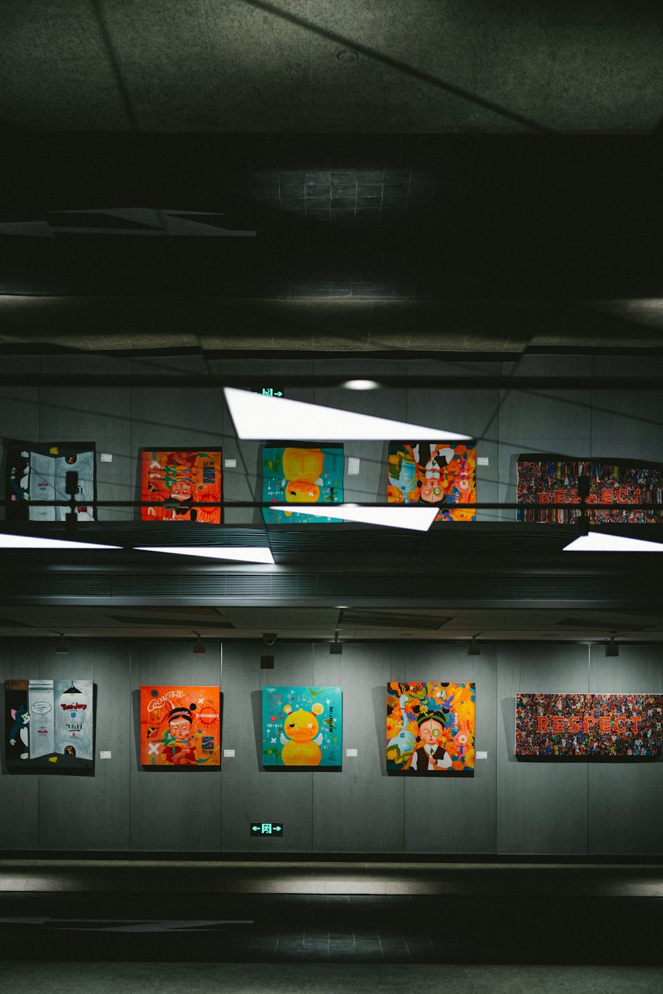 Kleurrijke pop-art schilderijen tentoongesteld aan een galerie-muur.